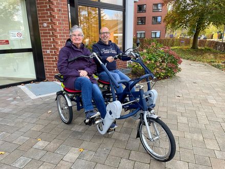 Seniorin und Betreuer fahren auf dem Tandem