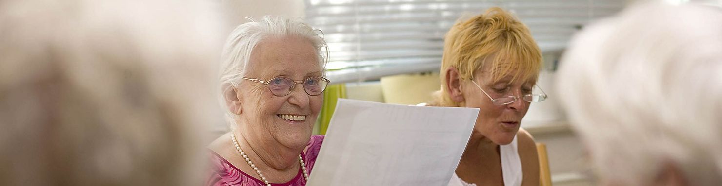 Ein Seniorin lächelt in die Kamera bei der Tagespflege im Hermann-Bonnus-Haus