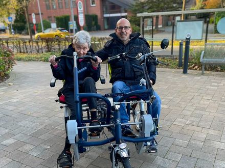 Seniorin und Betreuer fahren auf dem Tandem