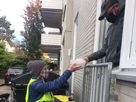 Diakonie Mitarbeiterin überreicht Mittagessen in Corona-Zeiten im Henkelmann