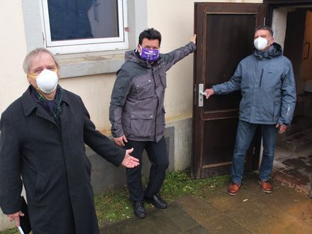 Das Foto zeigt von links nach rechts: Gerhard Töller, ehrenamtlicher Geschäftsführer der DiakonieStiftung Osnabrücker Land, Heiko Grube, Kuratoriumsvorsitzender und den leiter des örtlichen Sozialamtes vor einer Notunterkunft.
